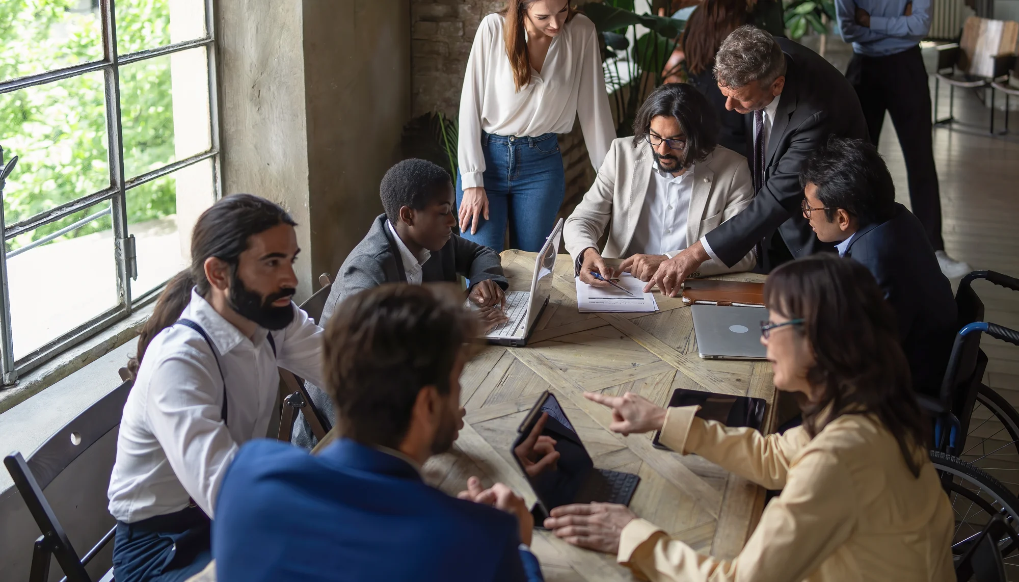 MitarbeiterInnen sitzen an einem Tisch in einem Business-Meeting