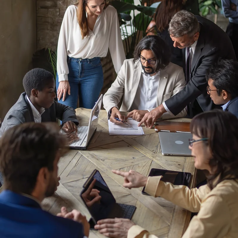 MitarbeiterInnen sitzen an einem Tisch in einem Business-Meeting