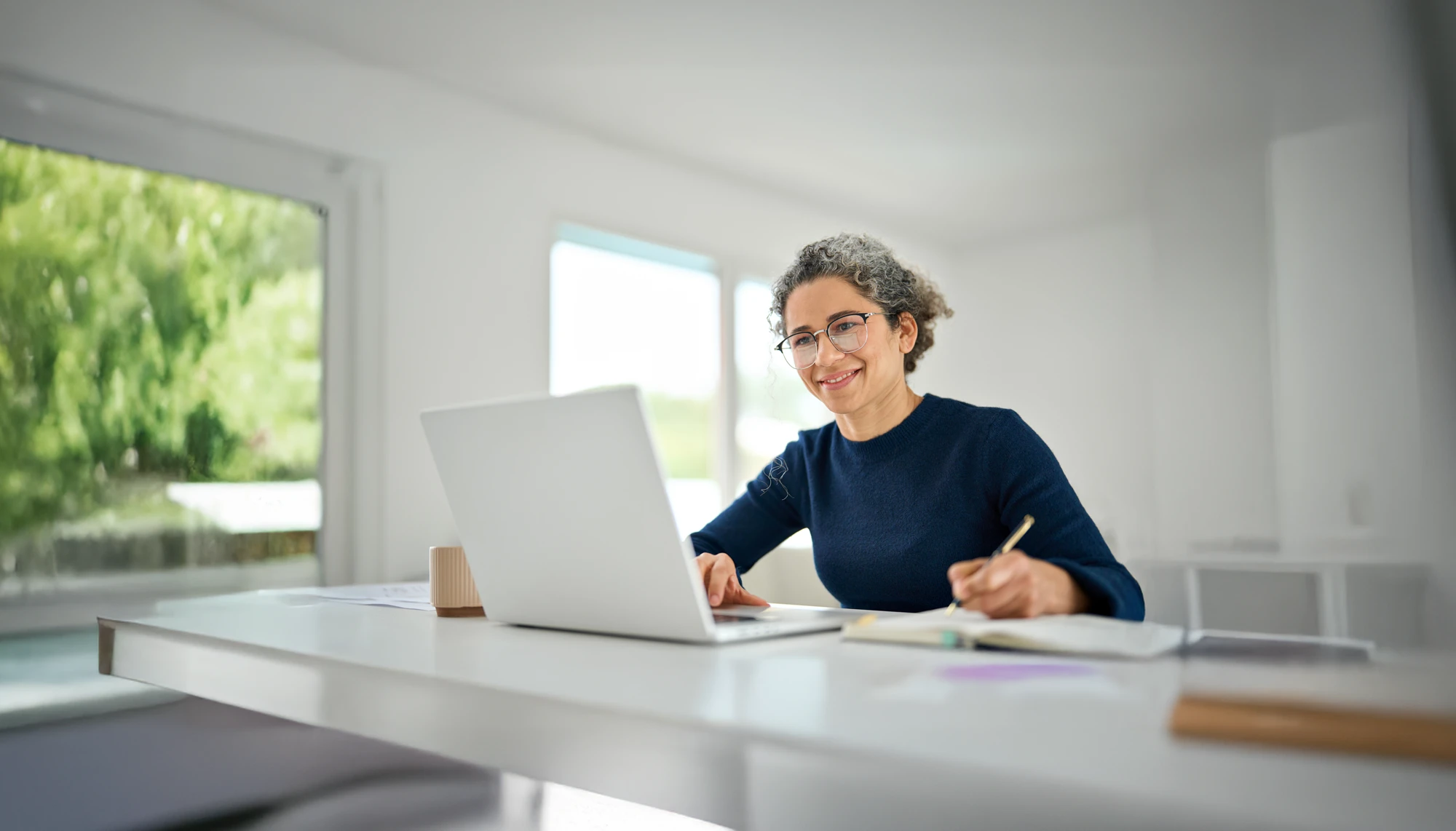 Ältere Mitarbeiterin arbeitet mit ihrem Laptop