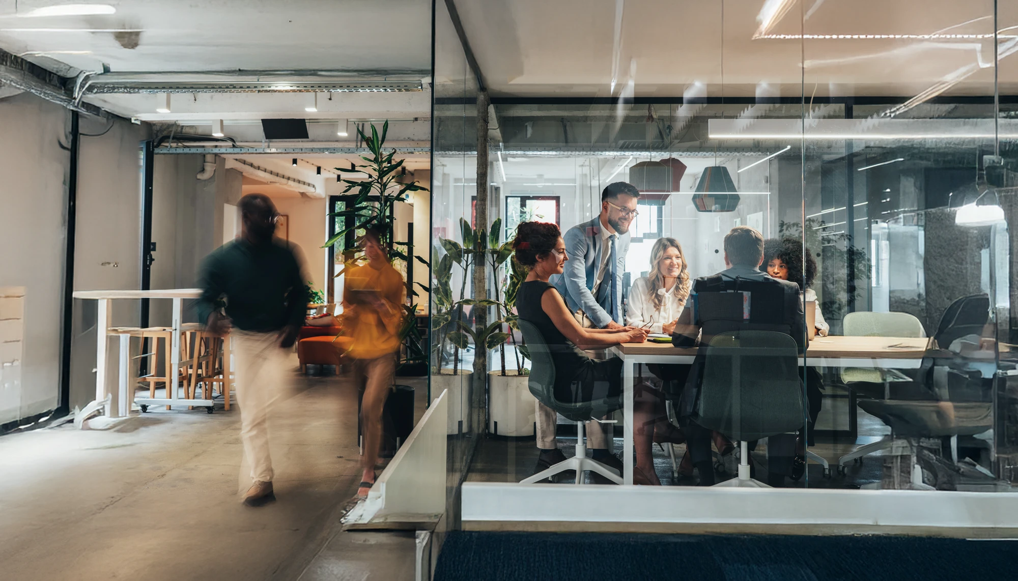 Diverse Mitarbeiter:innen in einem modernen, verglasten Büro