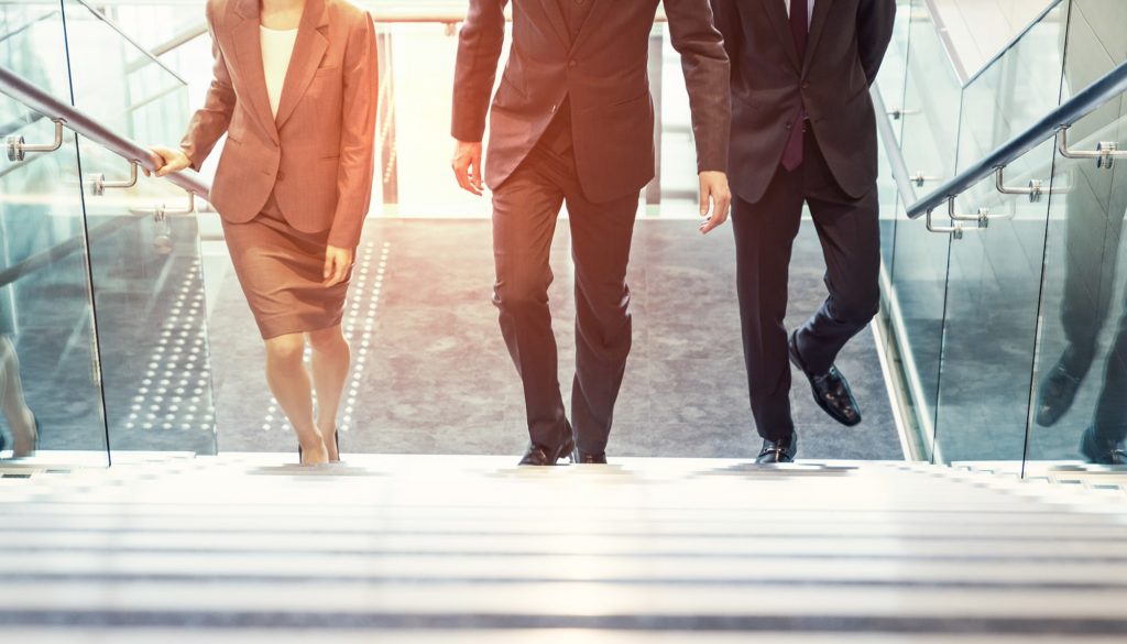 Training Gleichbehandlung statt Diskriminierung Geschäftsfrau und Geschäftsmänner gehen gemeinsam eine Treppe hinauf