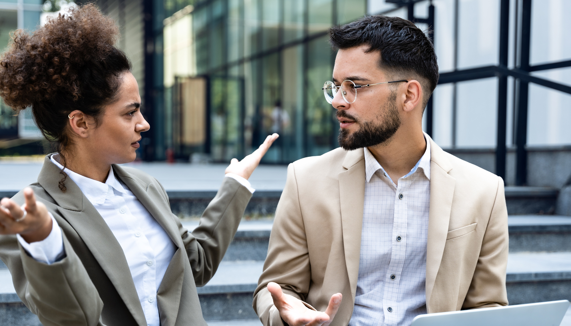 Mitarbeiterin in angespannter Gesprächssituation mit einem Kollegen